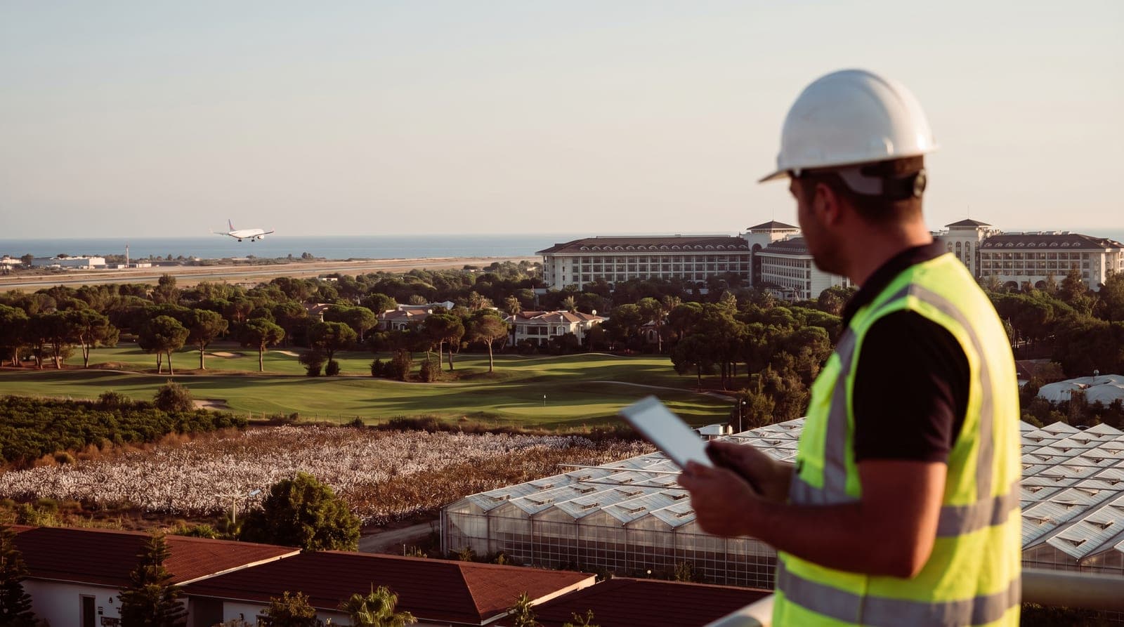 Serik iş güvenliği kursu — Belek golf oteli ve sahası önünde baretli iş güvenliği uzmanı